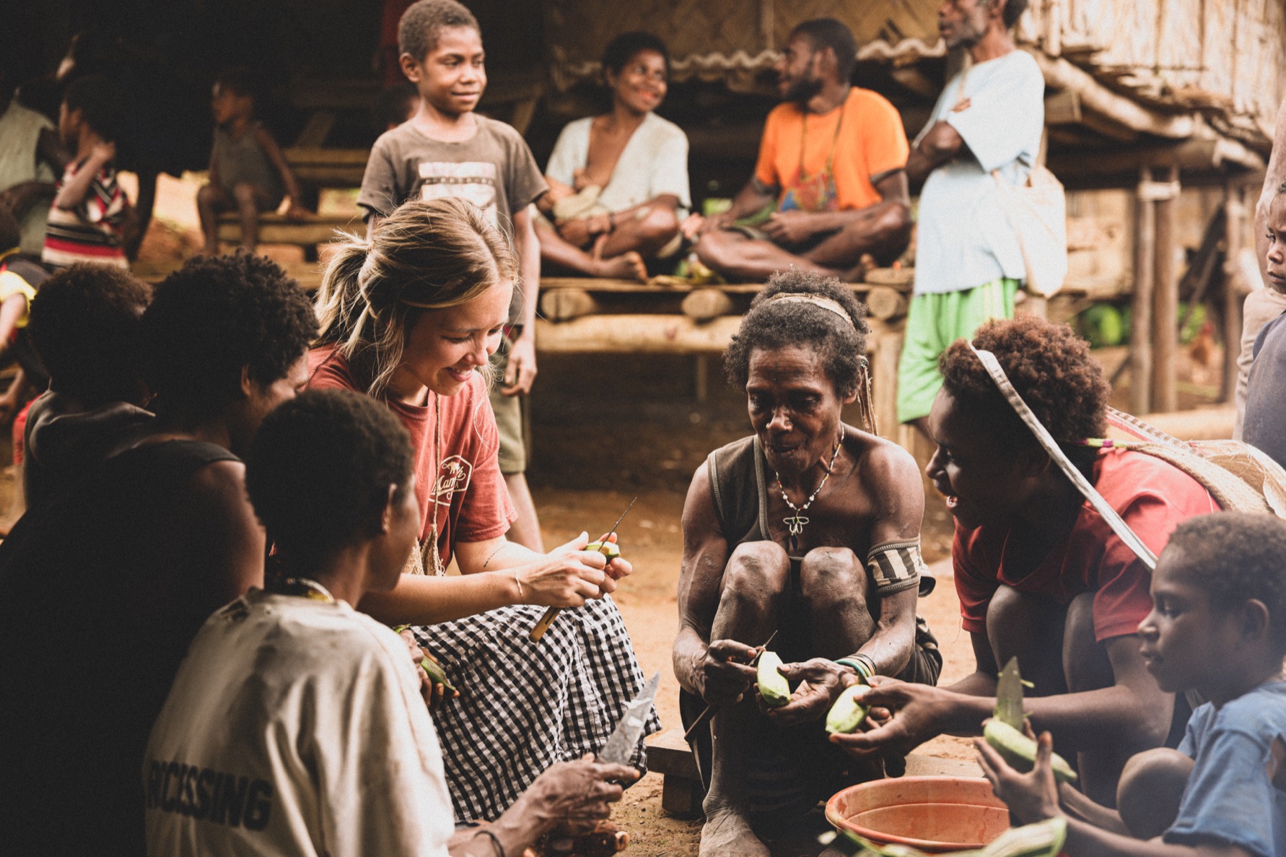 Friends preparing food together outside a village home.